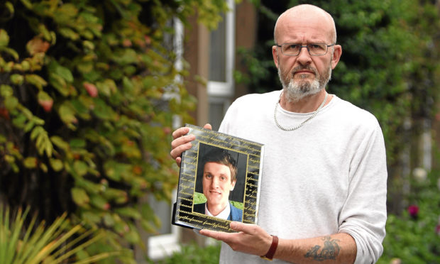 Phil Welsh with a picture of his son.