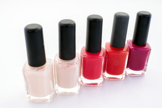 Different bottles of nail polish in different pink and red tones