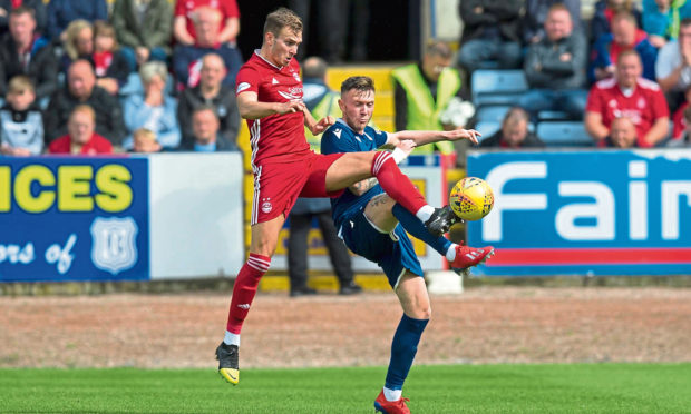 Ryan Hedges of Aberdeen challenges for the ball with Jordan McGhee of Dundee.