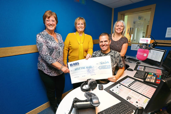 At WaveFM today are Kay Allardice, left, and Margaret McRae handing over the cheque for £1,000 raised from donations, instead of birthday presents, for Help For Kids to mid morning WaveFM DJ Craig Lumsden, with Stacey Wallace, right , Help For Kids Charity Manager.
