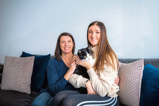Denise Oudney (left) and daughter Macy Harbut with cat Baxter.