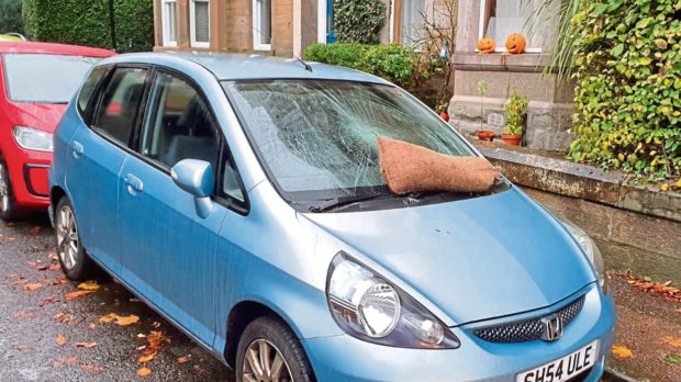 The blue car was spotted with its windscreen smashed by a sandbag after many student parties on Halloween.