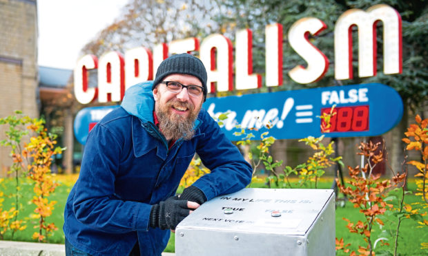 Steve Lambert with his installation in Nethergate, Dundee.