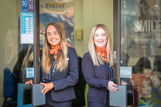Leanne Gall and Megan Wright opening the doors of Hays Travel in Dundee.
