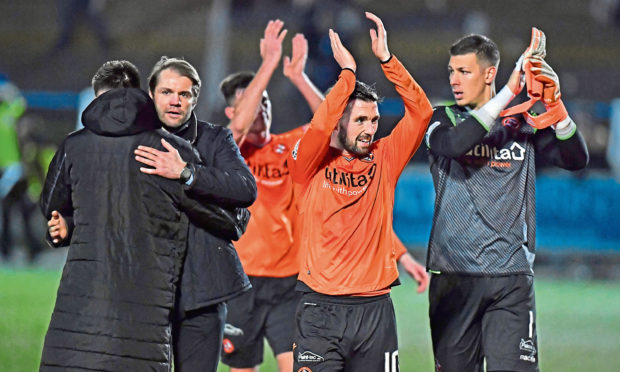 Dundee United manager Robbie Neilson, Nicky Clark, and Benjamin Siegrist applaud the travelling support at full time in Dumfries.