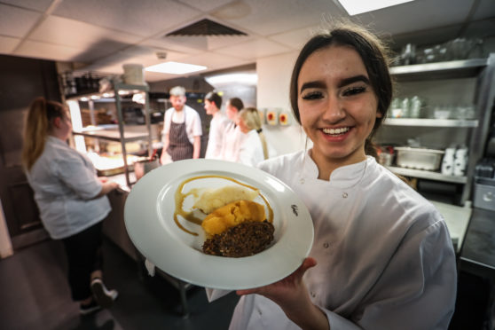 Chloe Sim, 17, serving up the mains of haggis, neeps and tatties.