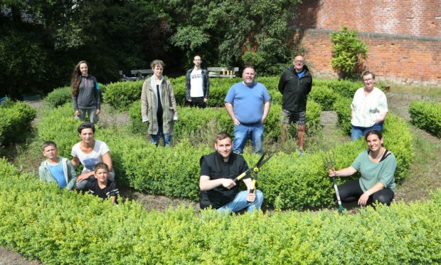 Tomasz Cackd (centre) in the Forebank Pocket Garden where along with other volunteers.