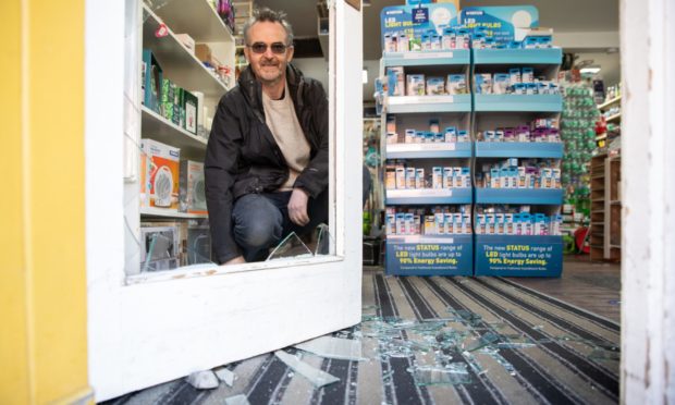 Kenny Watt and the smashed glass from the break-in at the Fobel Shop in Carnoustie. Photo by Kim Cessford / DCT Media