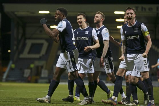 Dundee players celebrate their third goal against Hearts.
