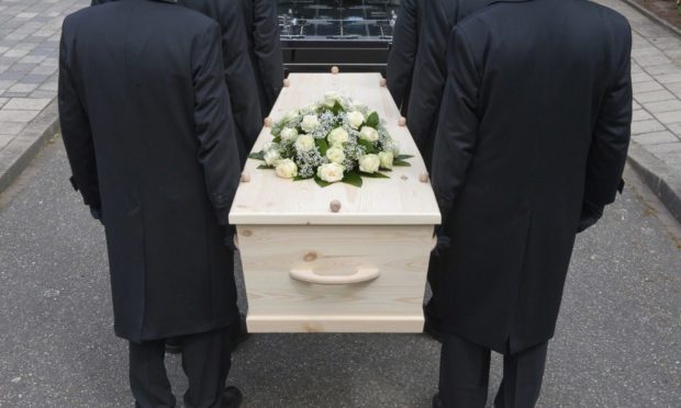 Bearers a carrying a coffin into a car