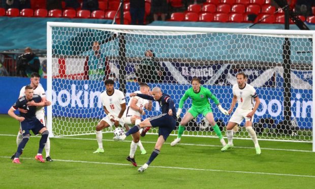 Scotland's Lyndon Dykes has this shot cleared off the line by Reece James.