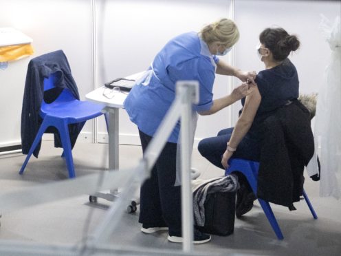 A nurse administers a coronavirus vaccine to a health and care staff member at the NHS Louisa Jordan (Jane Barlow/PA)