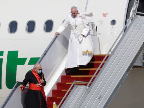 Pope Francis walks down the steps of an airplane as he arrives at Baghdad international airport, Iraq, Friday, March 5, 2021. Pope Francis heads to Iraq to urge the country’s dwindling number of Christians to stay put and help rebuild the country after years of war and persecution, brushing aside the coronavirus pandemic and security concerns. (AP Photo/Andrew Medichini)