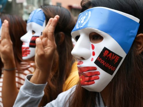 Young demonstrators flash the three-fingered symbol of resistance during an anti-coup mask strike in Yangon, Myanmar (AP Photo)