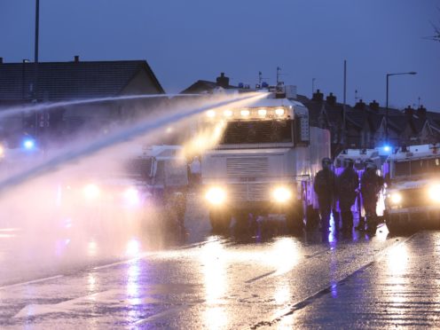 The PSNI use a water cannon on the Springfield Road, during further unrest in Belfast (Liam McBurney/PA)