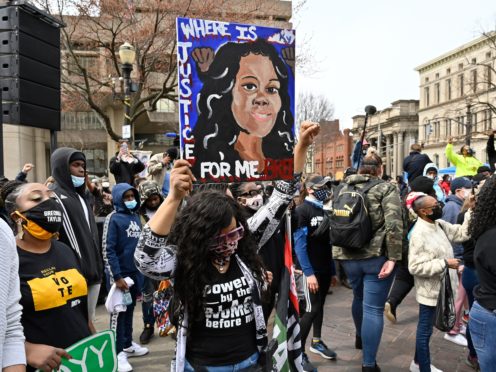 A protester holds up a painting of Breonna Taylor during a rally on the one year anniversary of her death at Jefferson Square Park in Louisville (Timothy D Easley/AP)