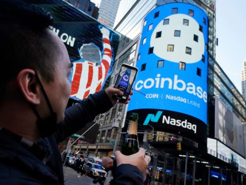 Coinbase employee Daniel Huynh holds a celebratory bottle of champagne as he photographs outside the Nasdaq MarketSite (Richard Drew/AP)