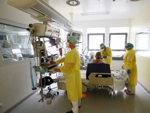 Medical personnel wearing protective equipment work in the intensive care ward for Covid-19 patients at the SRH Waldklinikum hospital in Gera, Germany (Bodo Schackow/AP)