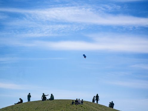 A man flies a kite during the warm weather on a hill at Northala Fields in west London (Victoria Jones/PA)