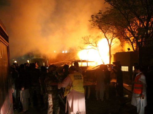 A police officer and rescue workers arrive at the site of a bomb blast in Quetta (Arshad Butt/AP)