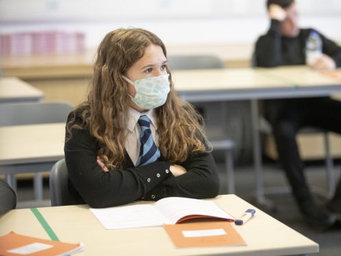 A student wears a protective face mask as the requirement for secondary school pupils to wear face coverings when moving around school comes into effect from today across Scotland (Jane Barlow/PA)