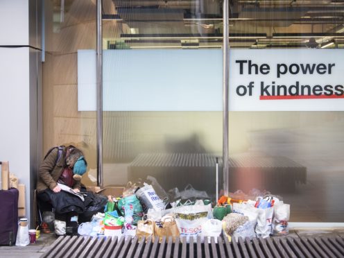 A homeless person sits next to a window in the City of London (Victoria Jones/PA)