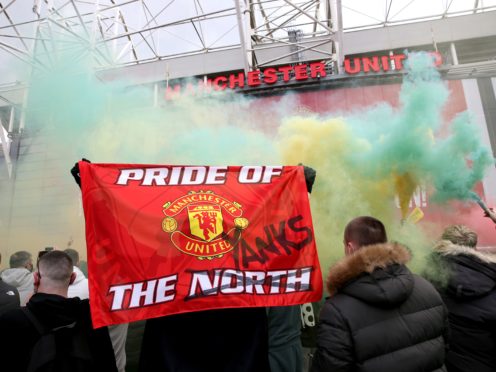 A fan holds up a banner as they protest against the Glazer family (Barrington Coombs/PA)