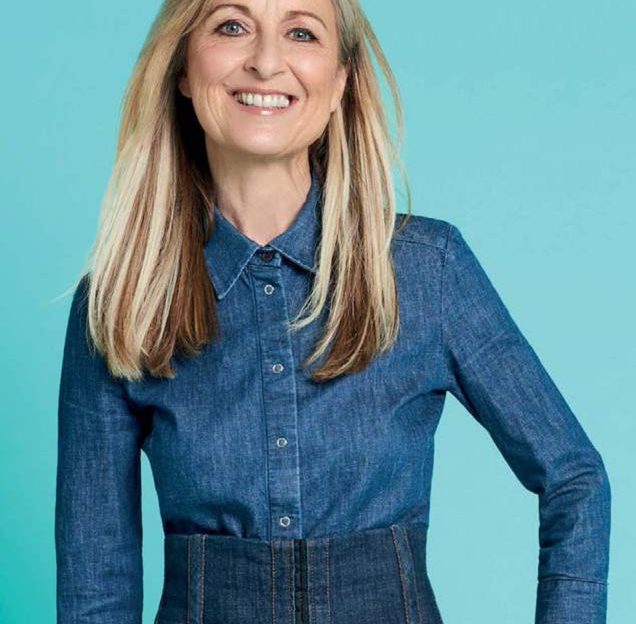 Fiona Phillips smiling at the camera on blue background