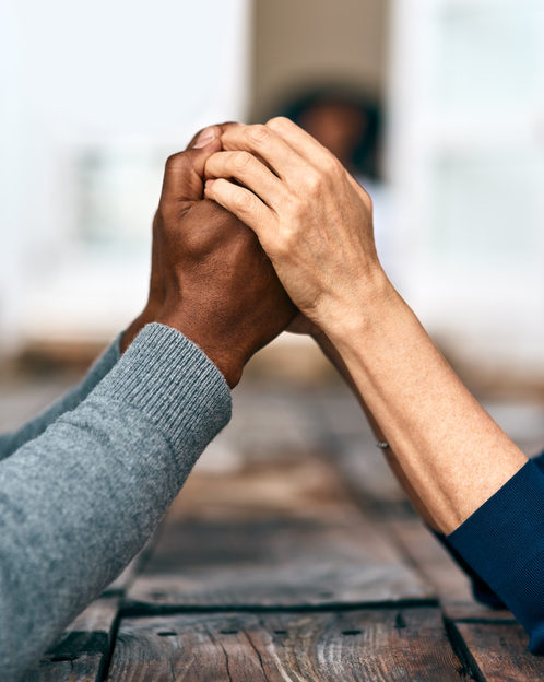 Two sets of hands clasping each other