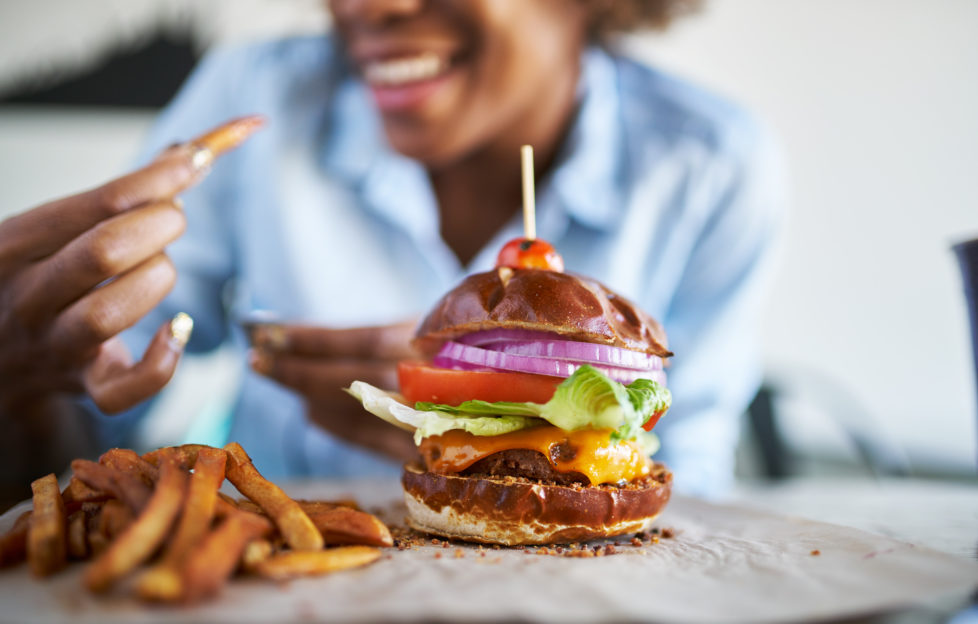 Woman getting ready to enjoy a burger and chips at the weekend