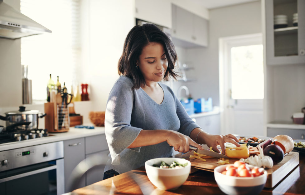 Young mum cooking her favourite dish to boost her wellbeing