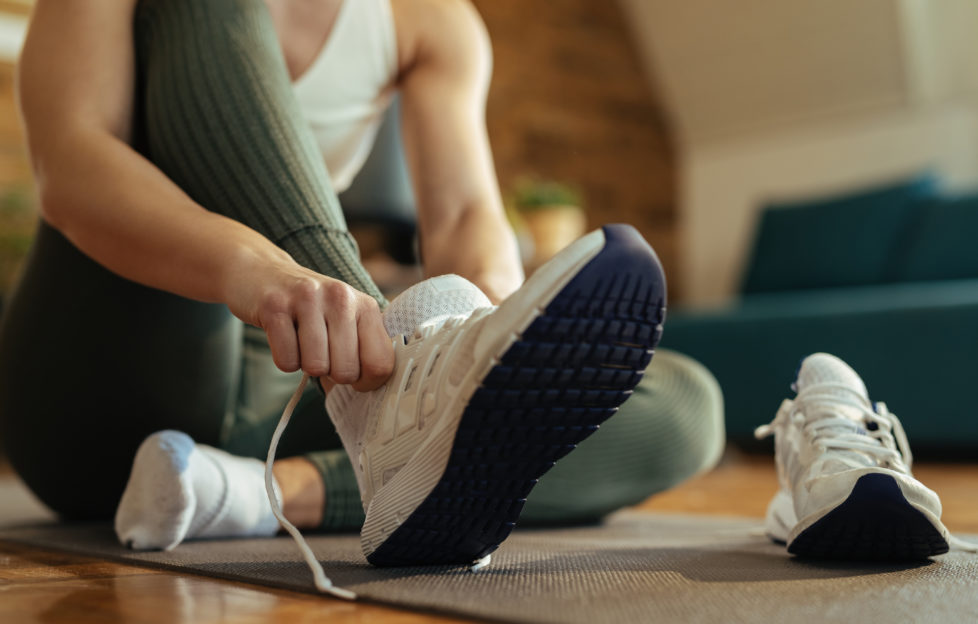Woman putting on trainers for indoor workout