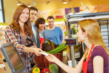 Lady smiling at supermarket checkout Pic: Rex/Shutterstock