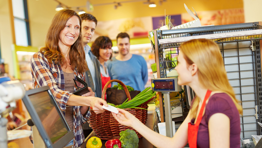 Lady smiling at supermarket checkout Pic: Rex/Shutterstock