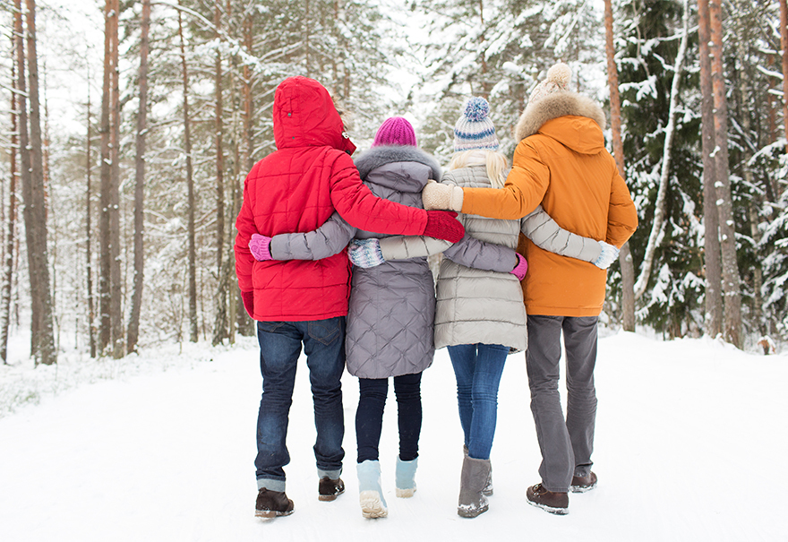 Reduce Christmas stress. A family walking through a snowy wood, arms round each other