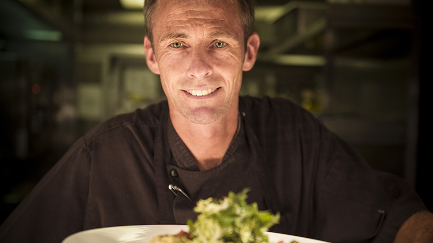 Head chef Garry Durrant with a plate of food topped with green leaves