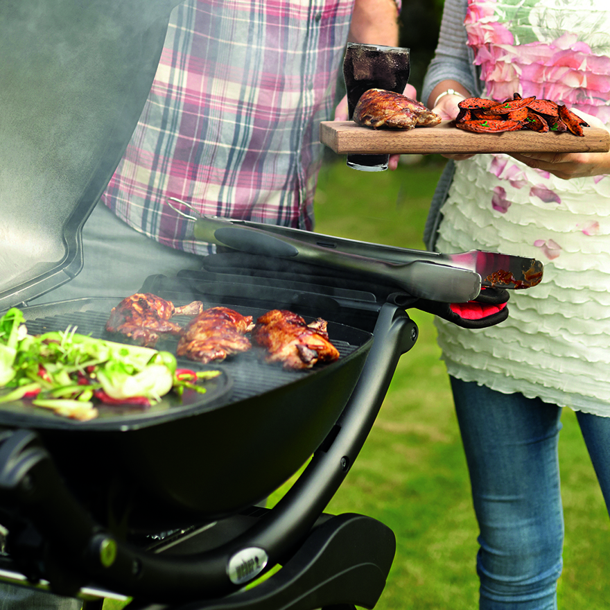 A couple barbecuing meat PIc: Weber® Q2200 BBQ with stand