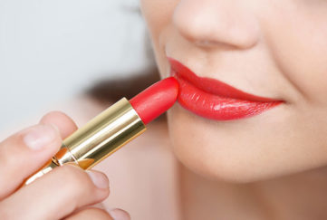 Lady applying red lipstick Pic: Istockphoto