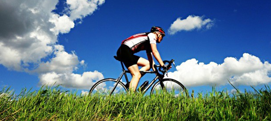 Person riding bike against very blue sky