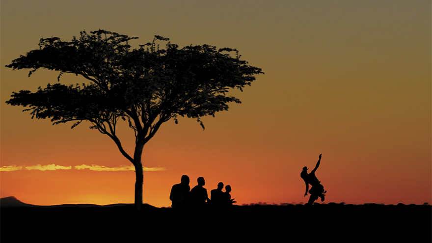 Cover of Listen To The Drums - a tree and a group of people silhouetted against a sunset in a cleat sky