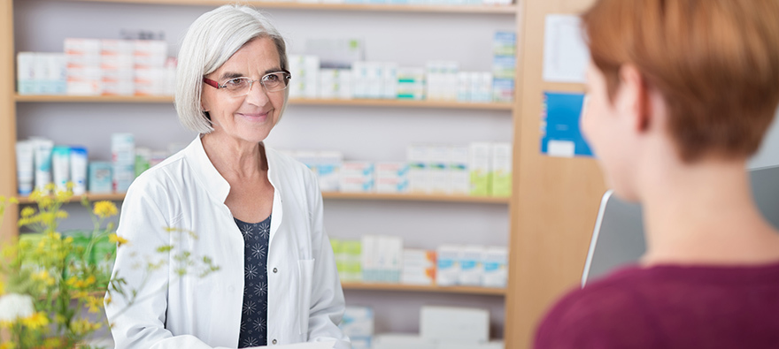 Pharmacist giving advice to woman in shop