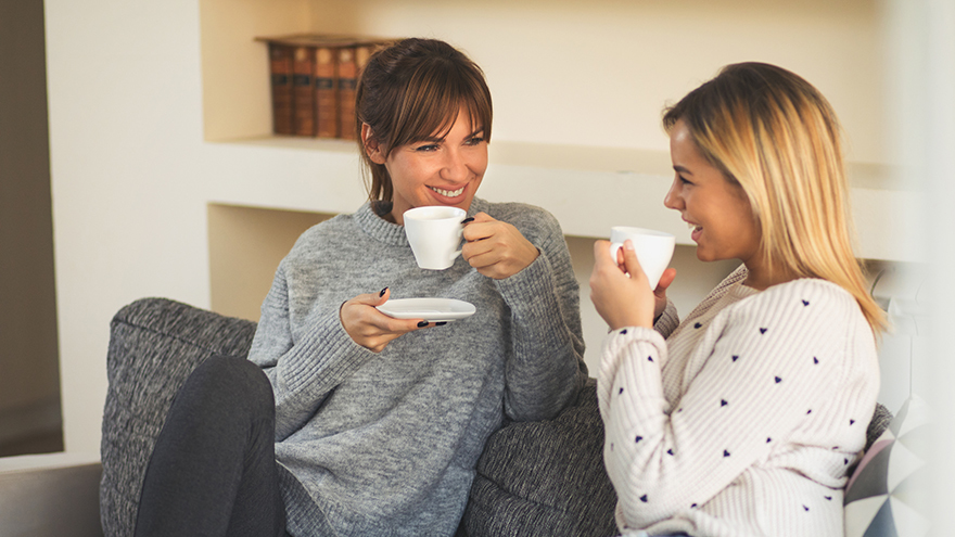 Two female friends enjoying coffee and small talk
