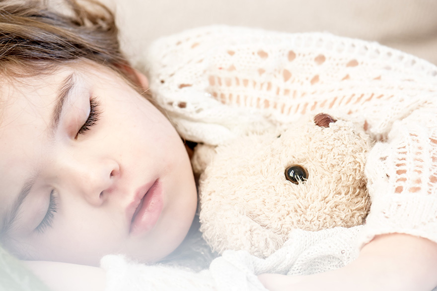 Child sleeping with teddy bear