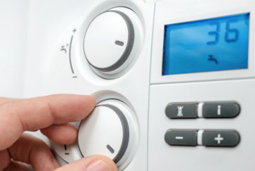 Close up of hand adjusting temperature on heat controls