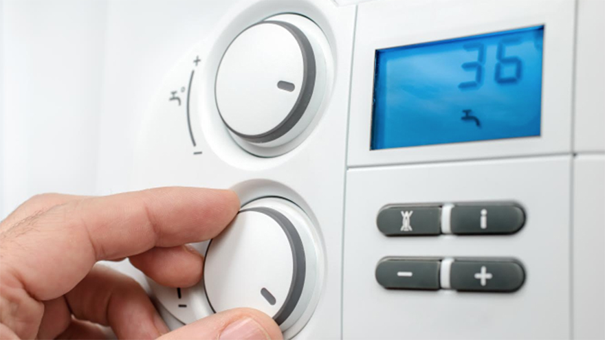 Close up of hand adjusting temperature on heat controls