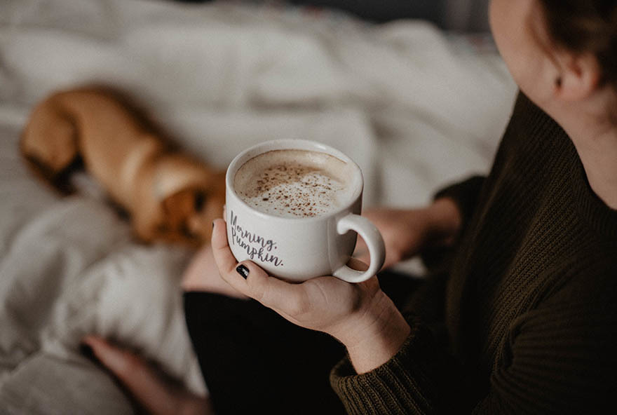 Woman relaxing with coffee and dog