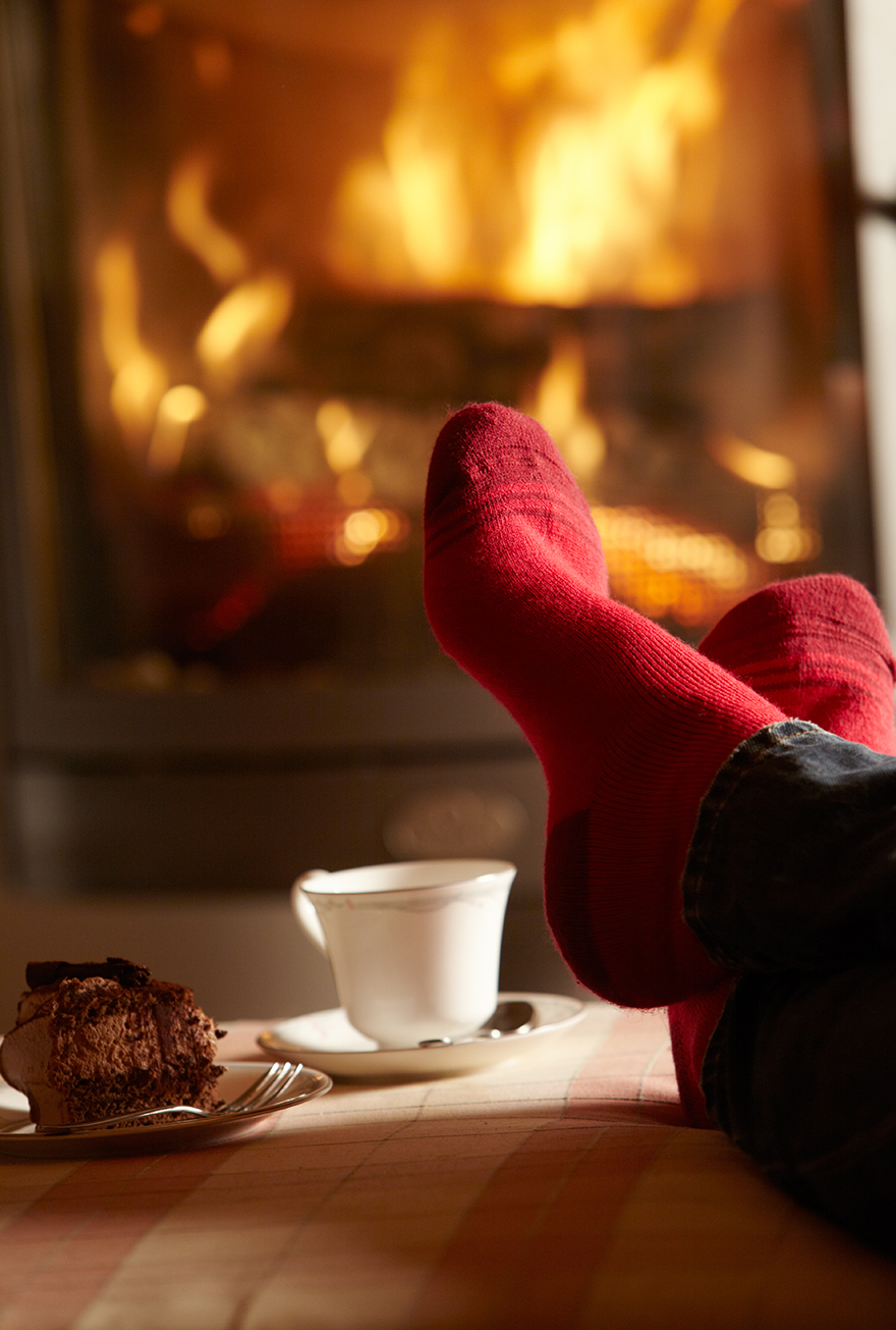 Pair of feet in red socks in front of fire