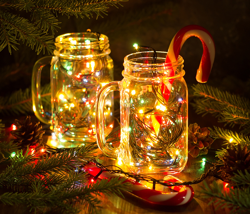Christmas fairy garland lights in a glass jar shine in the night darkness. 