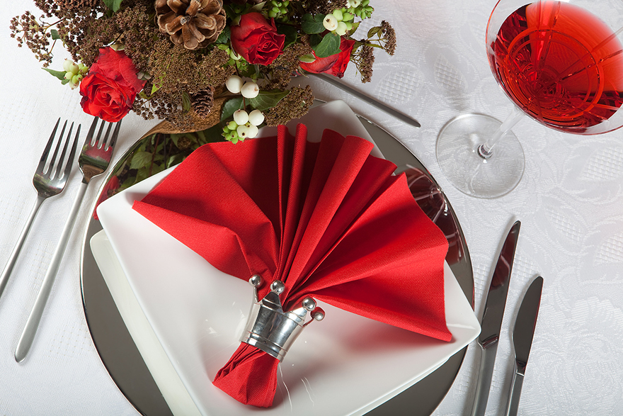 Festive Christmas table with red napkins on a white tablecloth
