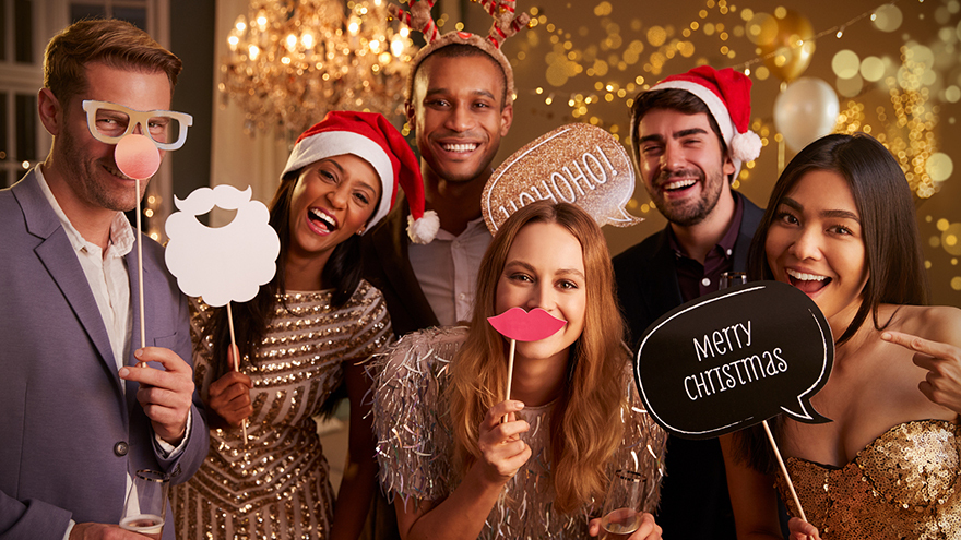 Group Of Friends Dressing Up For Christmas Party Together